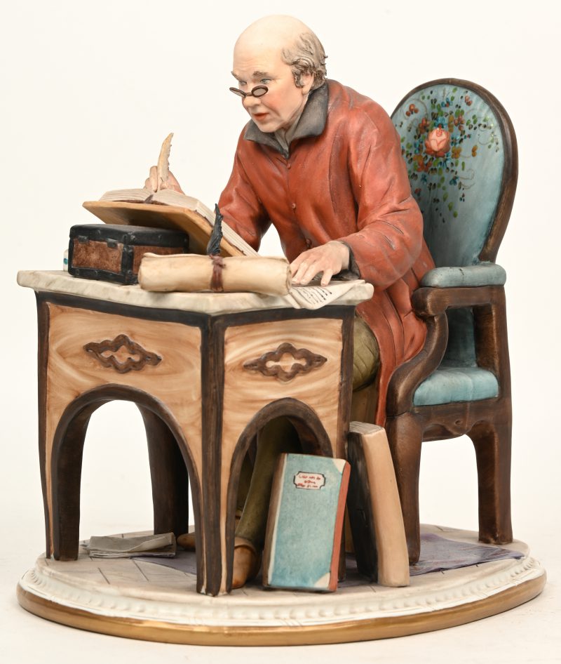 Een Capodimonte Volta beeldje van een schrijver aan bureau. Onderaan gemerkt.
