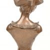 “Buste van een dame met hoed”. Een brons gepatineerd borstbeeld van een dame met hoed op een marmeren voet. Gesigneerd “Alphonse Piquemal”.