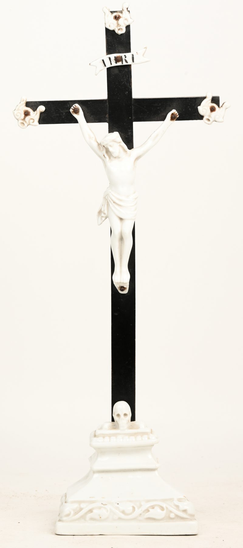 Een crucifix van wit porselein en houten kruis. 19de eeuws.