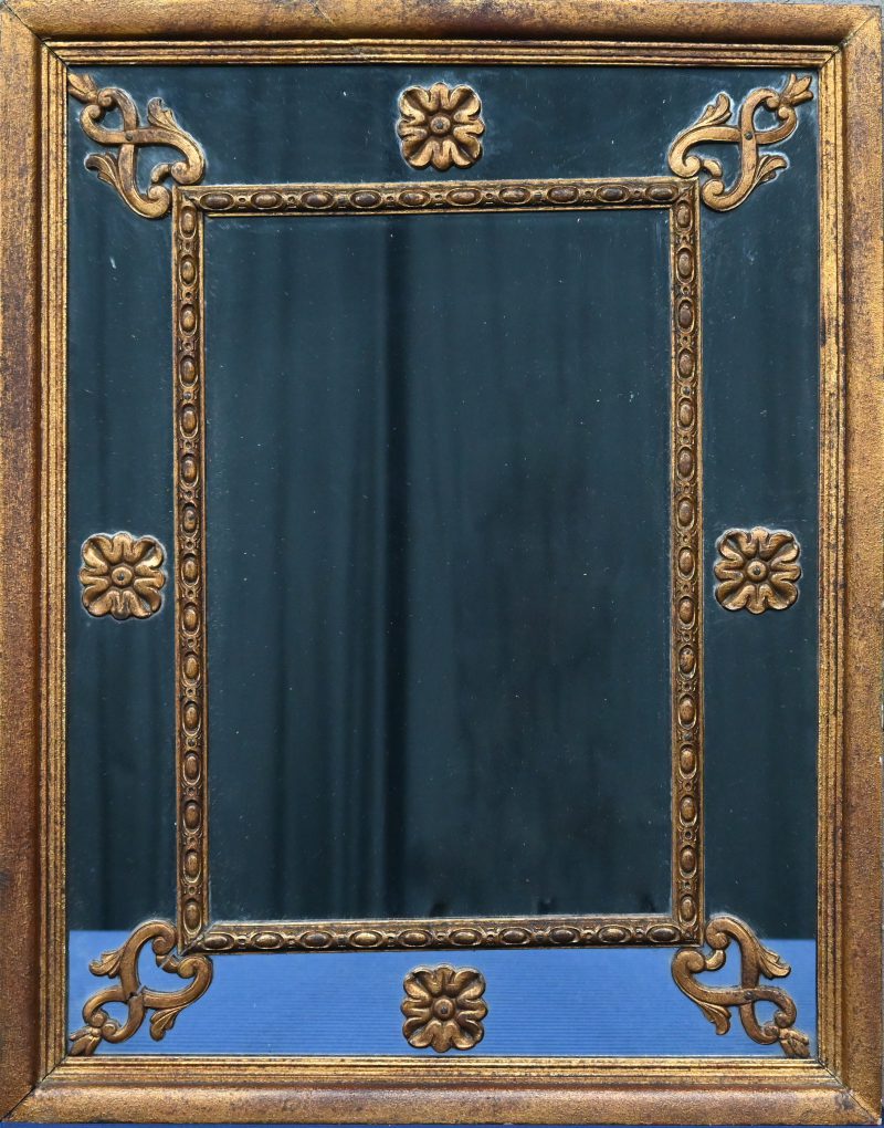 Een art deco spiegel met verguld kader en opgelegd frame binnenin. Kleine barst in frame bovenaan.