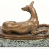 “Liggende windhond.” Bronzen beeld op groenmarmeren sokkel.