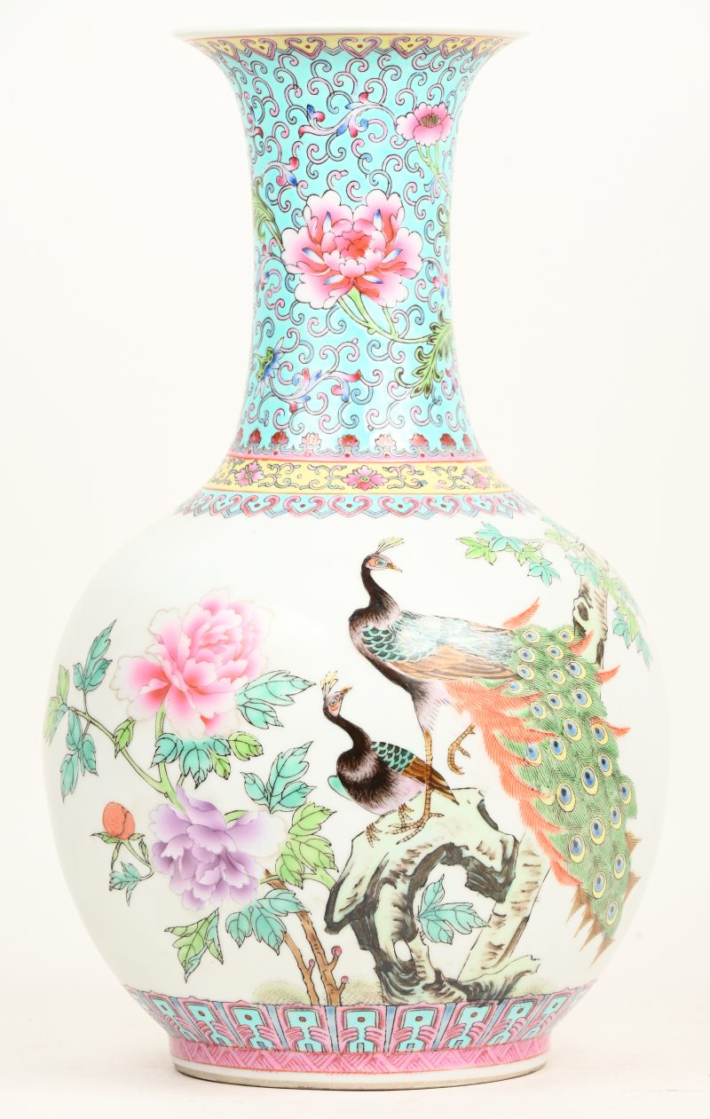 Een Chinees porseleinen vaas, famille rose, versierd met pauwen en divers gekleurd decor. Onderaan gemerkt.