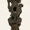 Bovendeel van een Mochica sierspeld in de vorm van een vos. Brons. Peru, VIIIste eeuw. Op een plexi sokkeltje.