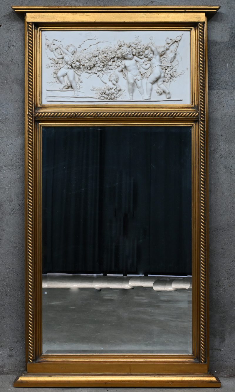 Een schouwspiegel in verguld houten lijst met bovenaan een bas-reliëf van engeltjes met bloemen.