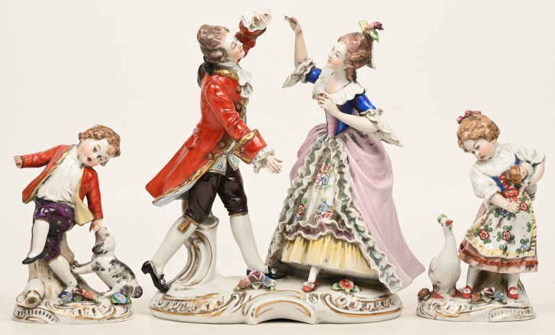 Een danspaar, een jongetje met en hond en een meisje met een gans. Drie beeldjes van polychroom Saksisch porselein. Onderaan gemerkt.