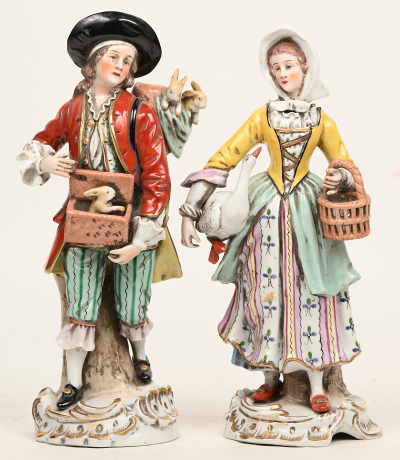 Een marktkramer met konijnen en een vrouw met een gans. Een paar beeldjes van polychroom Saksisch porselein. Onderaan gemerkt.