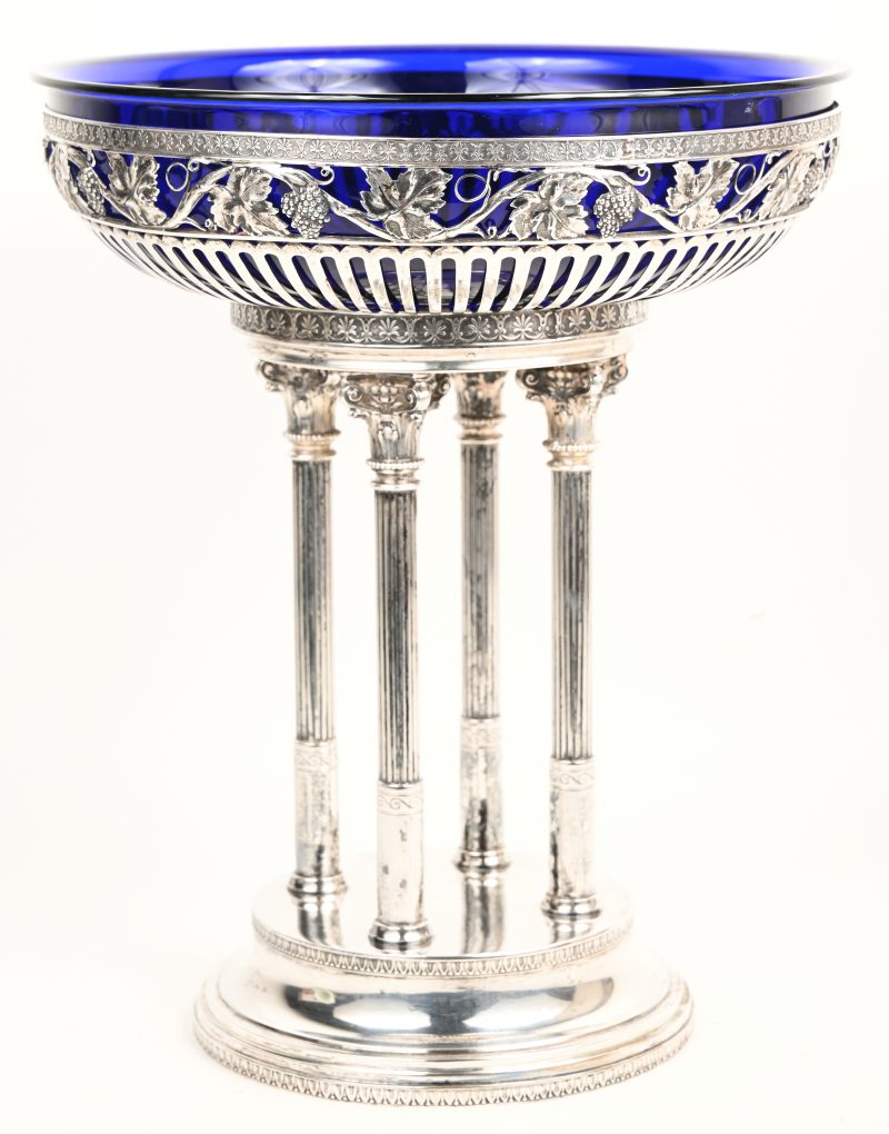 Milieu de table van zilver en kobaltblauw glas. Bestaande uit een coupe, gedragen door vier korinthische zuilen op een voetstuk. Duitse keuren, 800/1000.