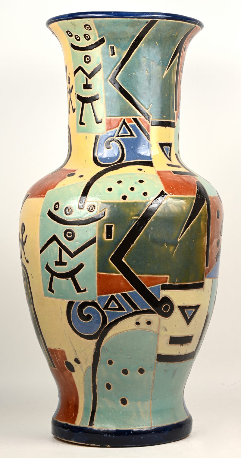 Een polychroom aardewerken vaas, modern decor met cyclopische abstracte figuren.