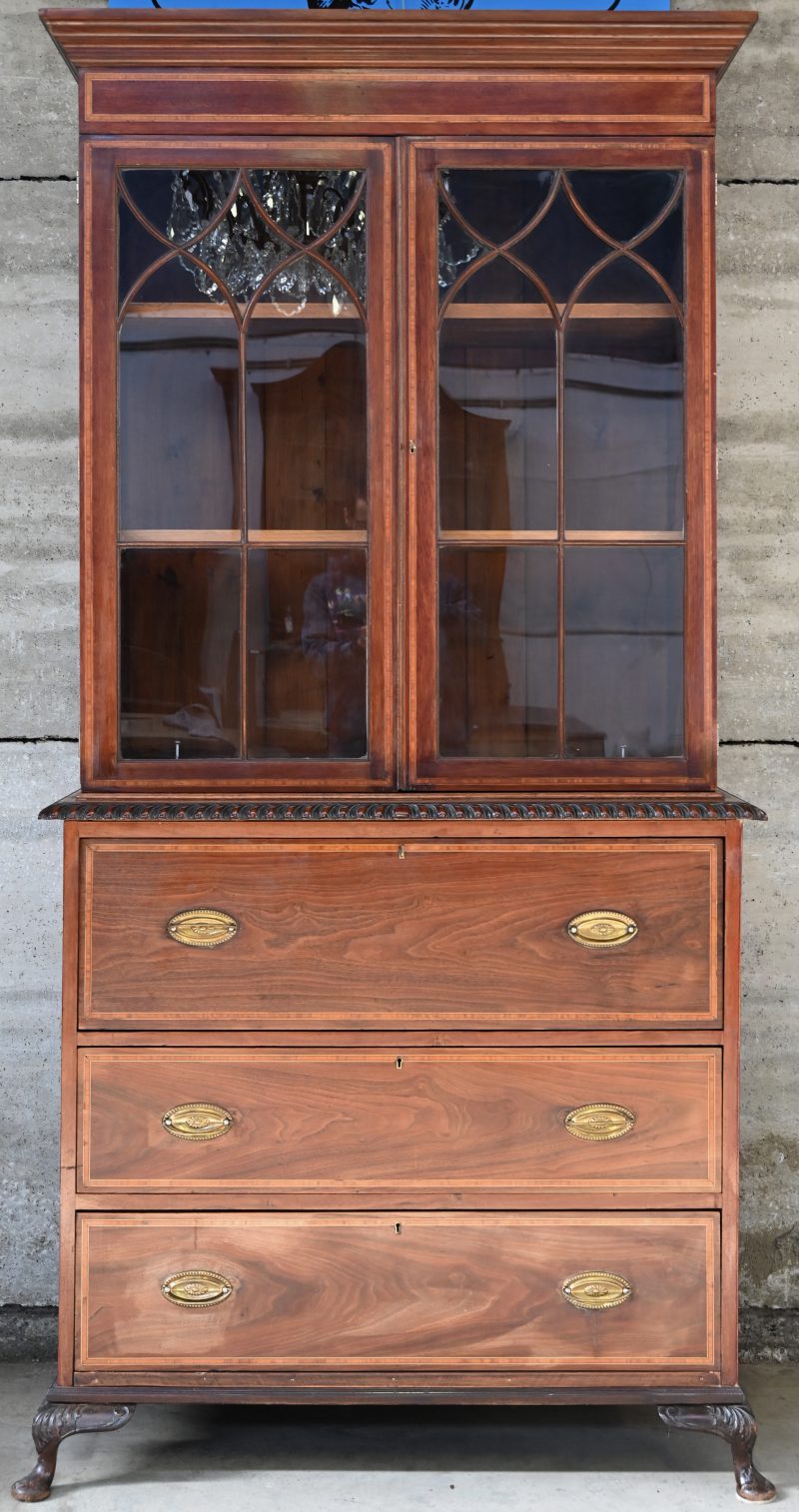 Een mahoniehouten vitrinekast met secretaire. 2-delig met 2 lades en 2 glazen deuren.