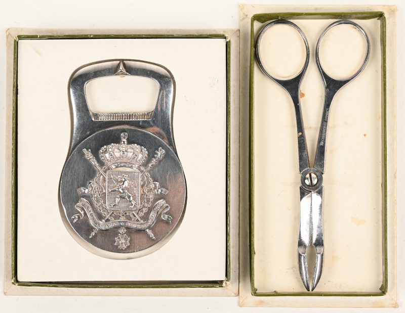 Een lot bestaande uit een verzilverde medaille met opschrift “Eendracht maakt macht”, in de vorm van een kroonkurk opener. En een verzilverd knijpschaartje, “Sugar Scissors”.