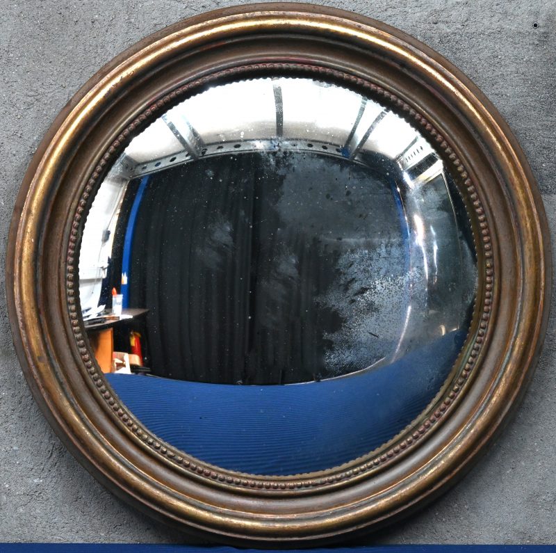 Een rondvormige Butler spiegel met houten verguld kader.