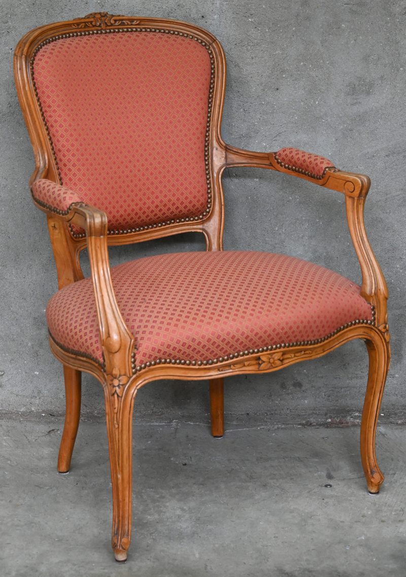 Een hout gesculptuurde Louis XV stoel met armleuning en gestoffeerde zitting.