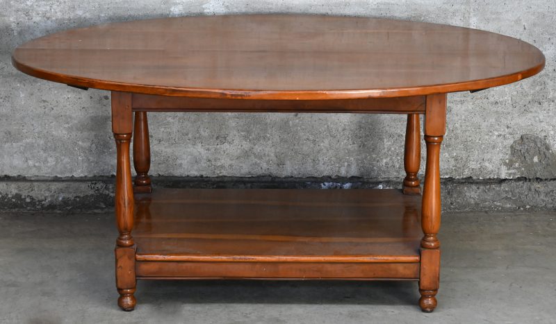 Een ovaal houten salontafel met onderschap.