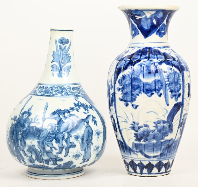 Twee diverse vazen van Chinees blauw en wit porselein, de éné met een decor van personages in een landschap, de andere met bloemen in uitsparingen.  Eén beschadigd aan de onderrand, de andere met een kleine perforatie onderaan.