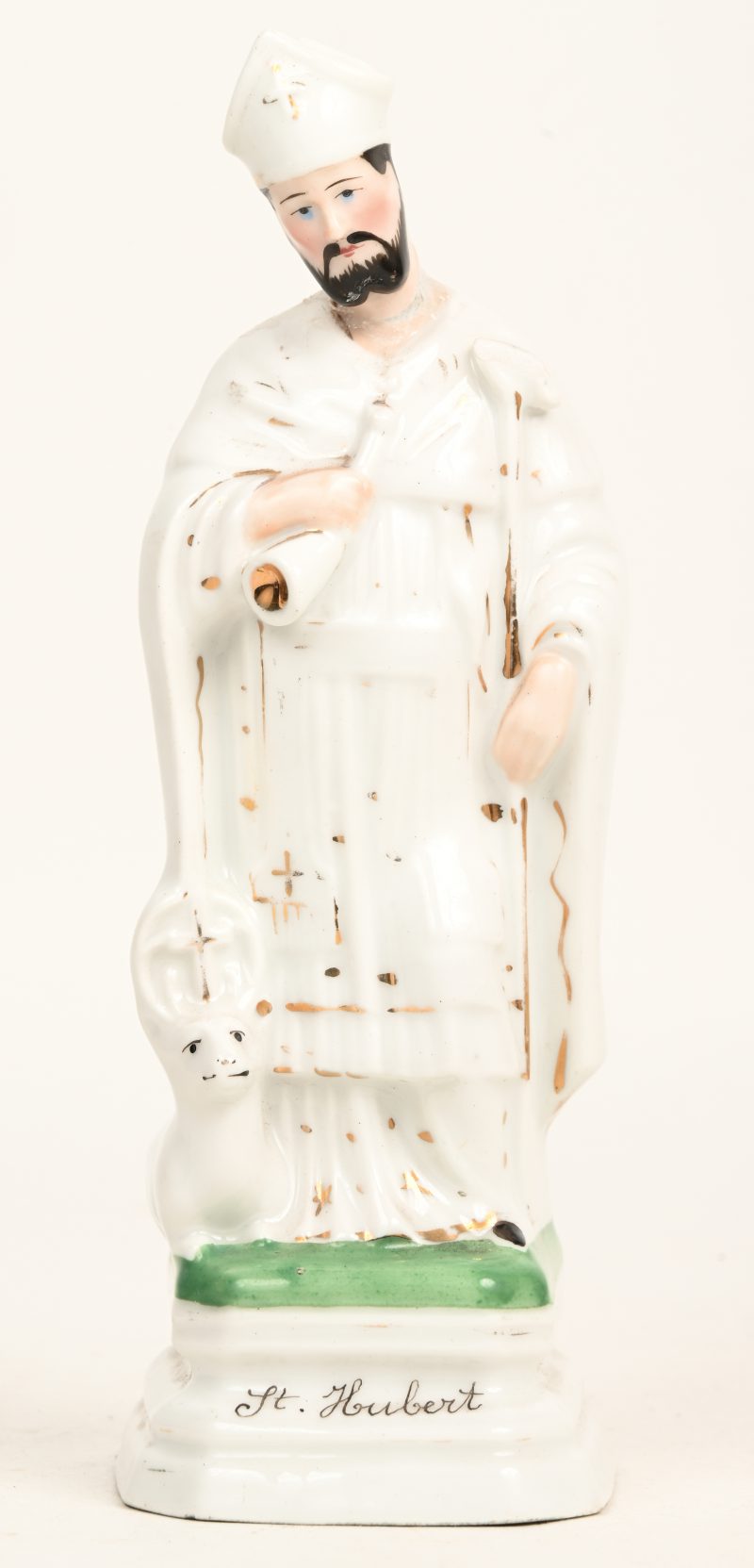 Een onthoofd porseleinen beeldje van St. Hubert. Lijmsporen door breuk-en herstelschade thv het hoofd.