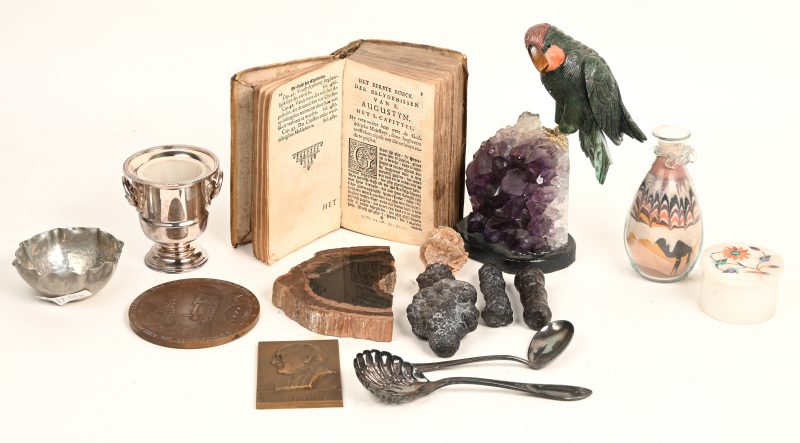 Een lot varia, bestaande uit een verzilverd tafelemmertje, een papegaai van verschillende gesculpteerde mineralen op een fractie amethist, twee bronzen plaquettes, een oude misaal, enz.