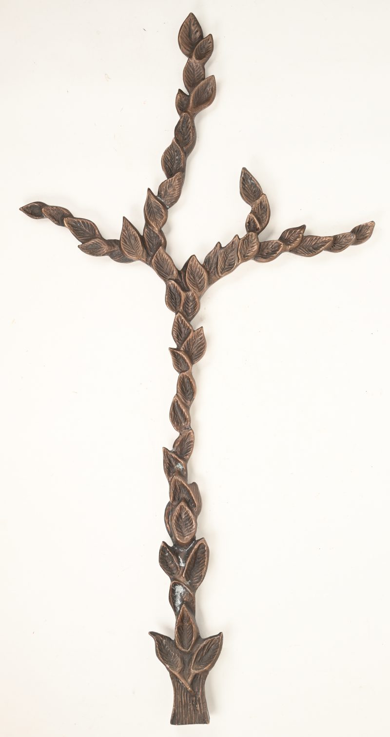 Een bronzen kruis in de vorm van bladeren.