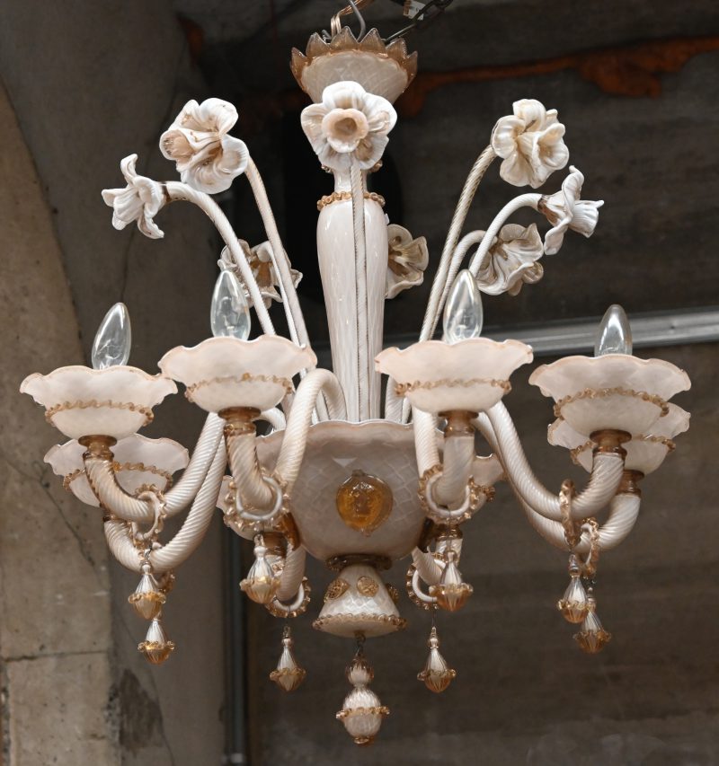 Een Murano glazen luster. 8-armige lichtpunten en bloemen in het decor.