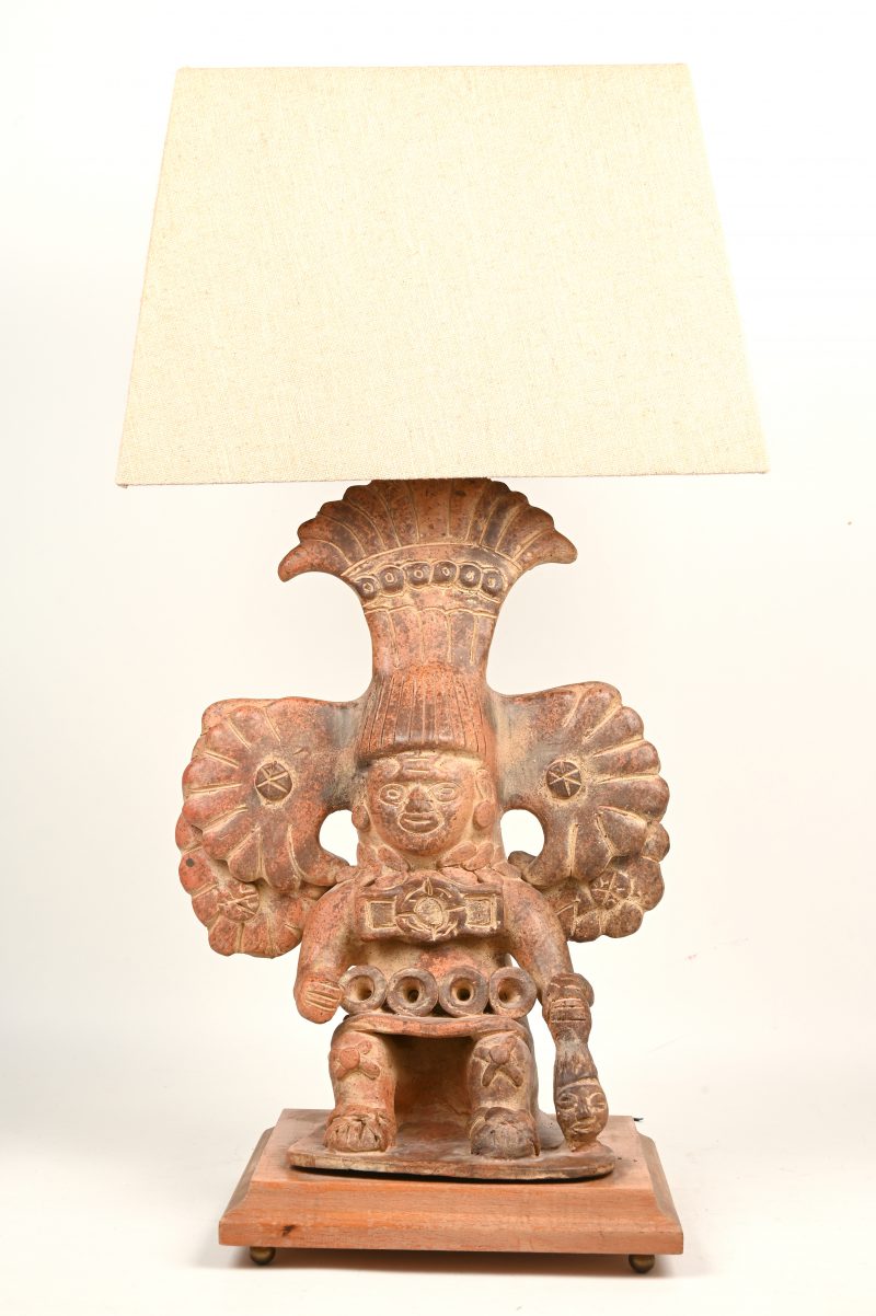 Een vintage tafellamp bestaande uit een mexicaans terracotta beeld met een stoffen kap.