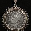 Een zilveren ketting met zilveren medaillon met 50 Belgische Frank met afgebeeld Boudewijn en Fabiola.