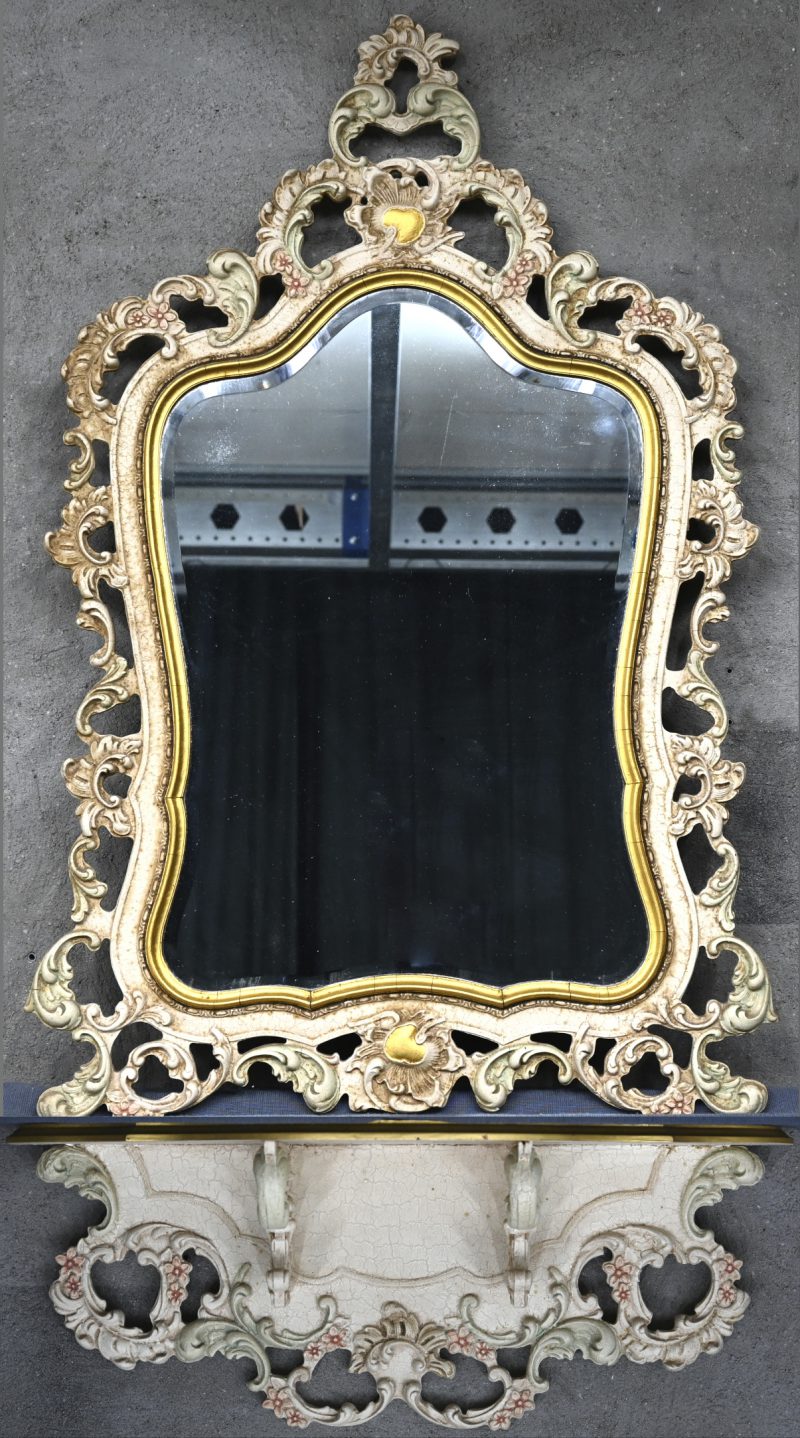 Een spiegel met hout gesculptuurd frame en muursokkel.