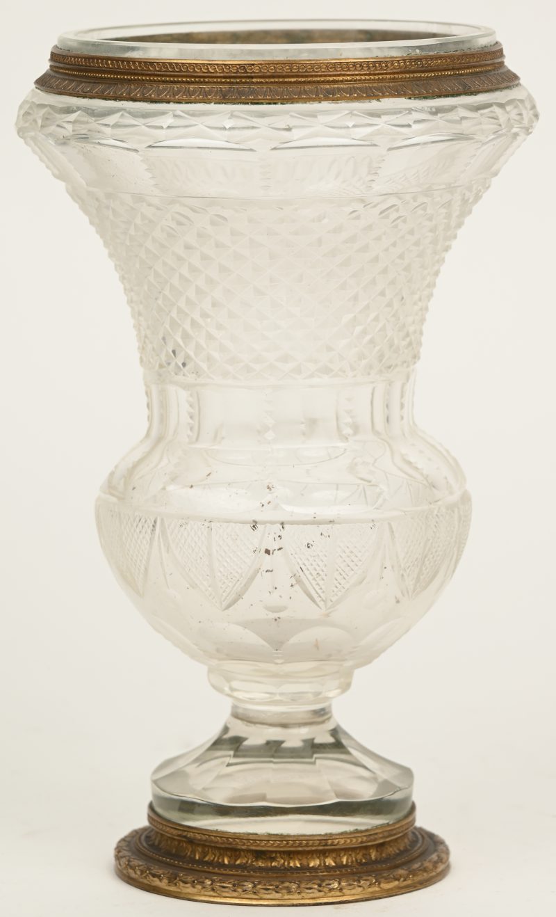 Een glazen vaas met vergulde rand en geslepen details.