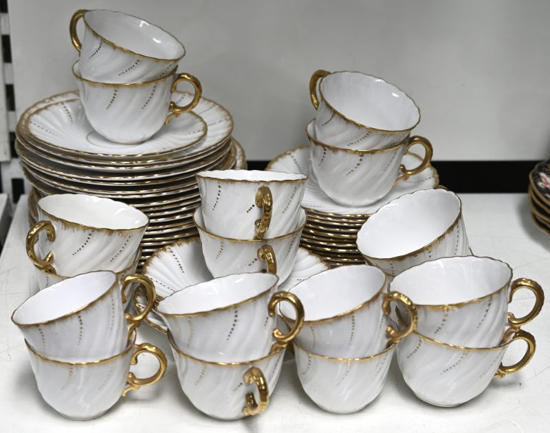 Een wit porseleinen koffieservies met vergulde randen en details, 54 stuks. Onderaan gemerkt “Sarreguemines France”.