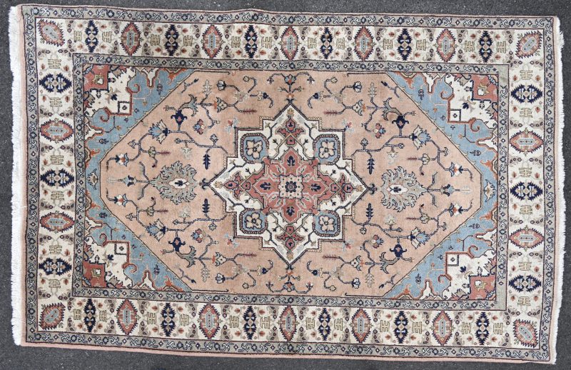 Een handgeknoopt wollen Perzisch tapijt.