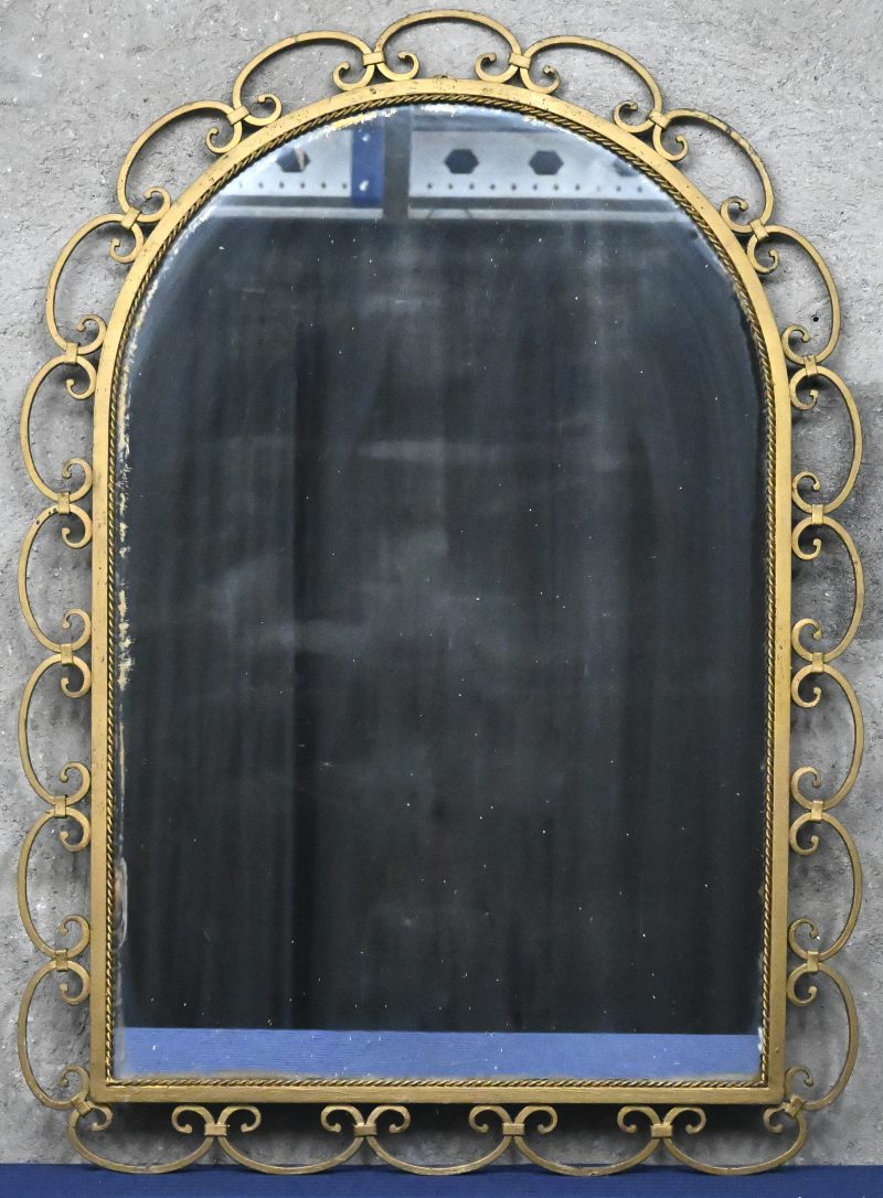 Een spiegel met vergulde metalen frame.