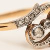 Een paar 18 karaats wit en geelgouden oorbellen en bijpassende ring bezet met diamanten oude slijp met een gezamenlijk gewicht van +- 0,60 ct.