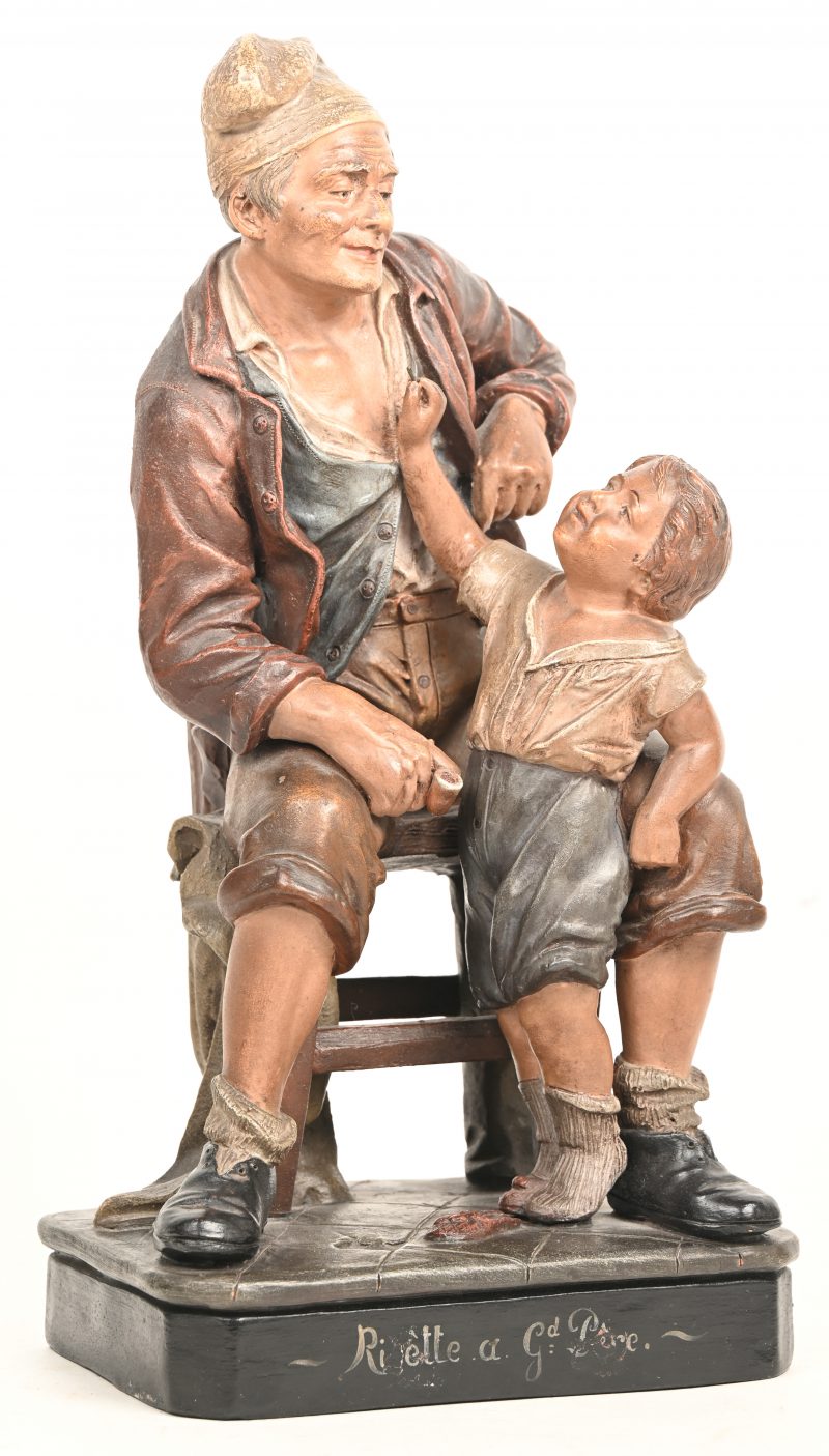 “Grootvader met kleinzoon”. Een beeld in gepolychromeerde terracotta, gesigneerd “F. Foucher”.