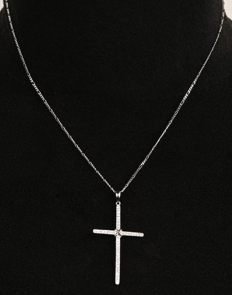 Een 18 karaats witgouden ketting met hanger in de vorm van een kruis bezet briljanten met een gezamenlijk gewicht van +- 0,24 ct.