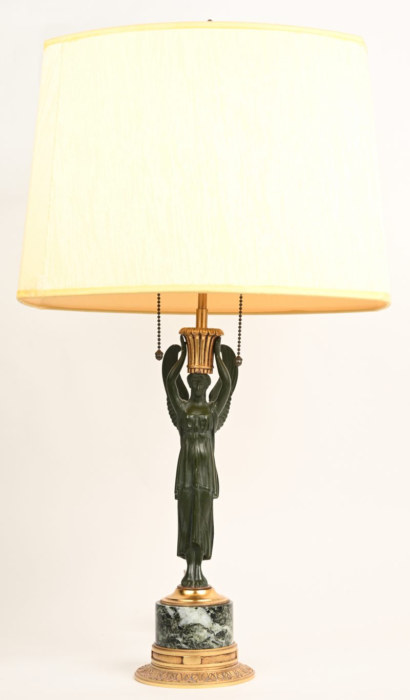 Een brons gesculptuurde tafellamp op marmer en messing voet, Empire stijl.