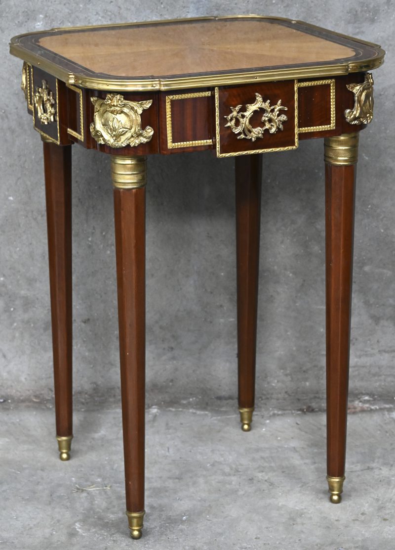 Een Baroque stijl tafeltje met gesculptuurde ornament in verguld kunstbrons.
