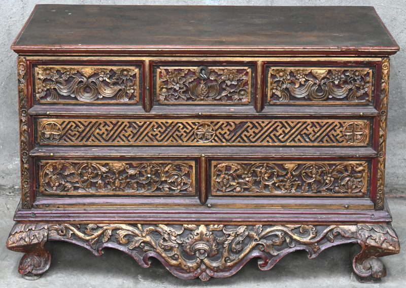 Een houten Chinese opbergkist met snijwerk in het decor.