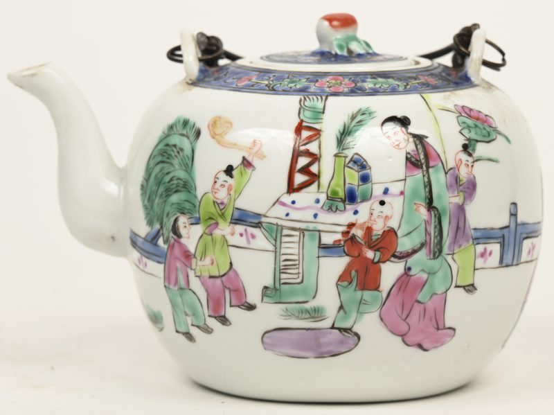Een Chinees porseleinen theepot met spelende figuren in het decor. Onderaan gemerkt.