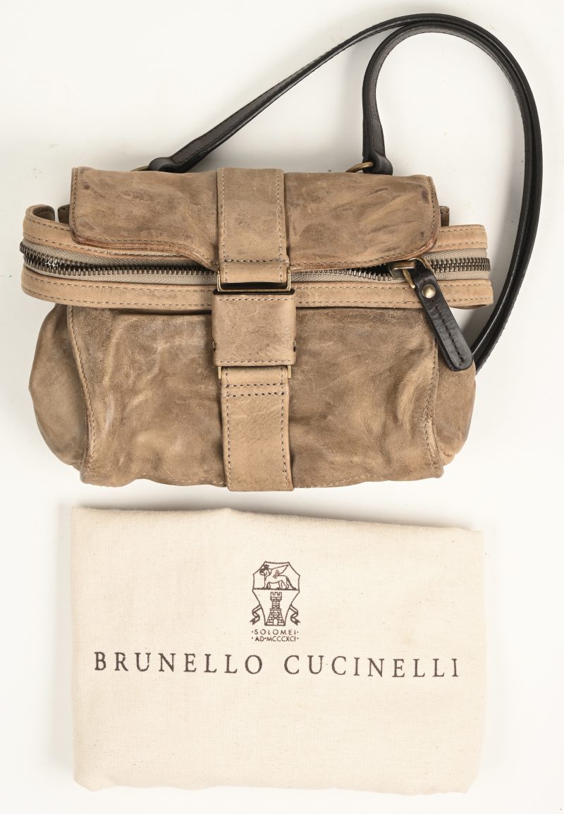 Een lederen tasje met bijhorende stofhoes, gemerkt “Brunello Cucinelli”. Lichte gebruiksporen.
