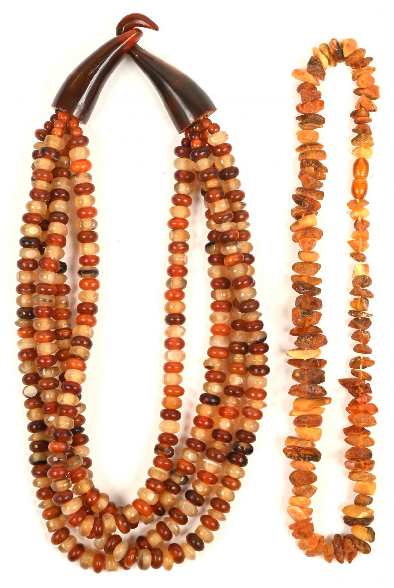 Twee verschillende halssnoeren bezet met half edelstenen van amber.