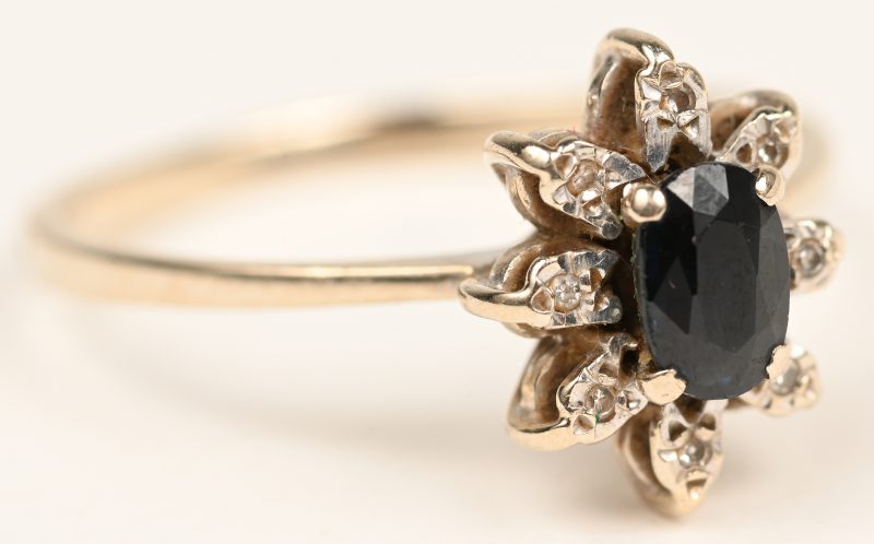 Een 18 karaats witgouden ring bezet met kleine diamantjes en een ovale saffier van +- 0,40 ct.