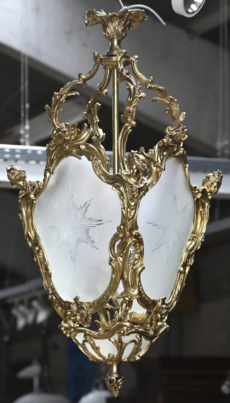 Een vierzijdig bronzen lantaarn met geslepen glas.