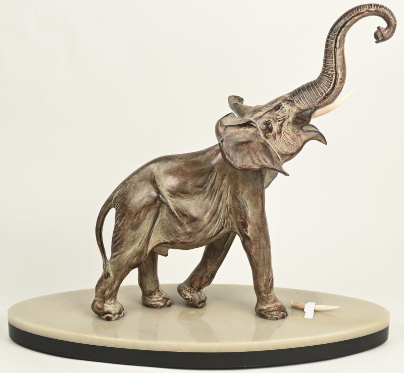 Een kunstbronzen beeldje van een olifant op marmeren voet. Gesigneerd onderaan op voet “Gilquart”.