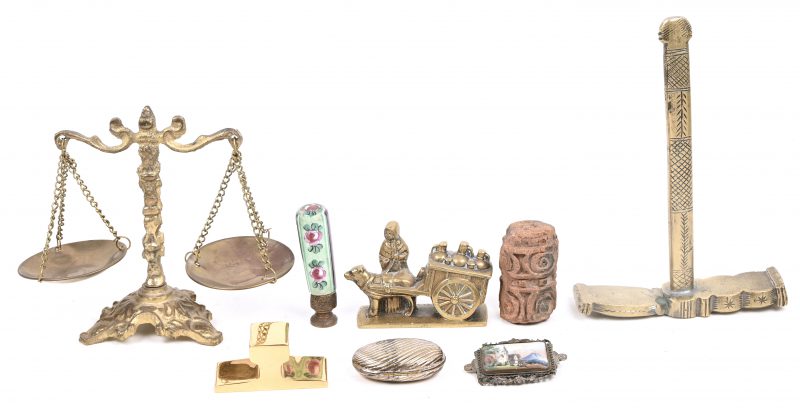 Een lotje van 8 snuisterijen in koper, porselein en steen bestaande uit een hamertje, weegschaal, 2 beeldjes, aambeeld, pillendoosje, lakzegelstempel en broche.