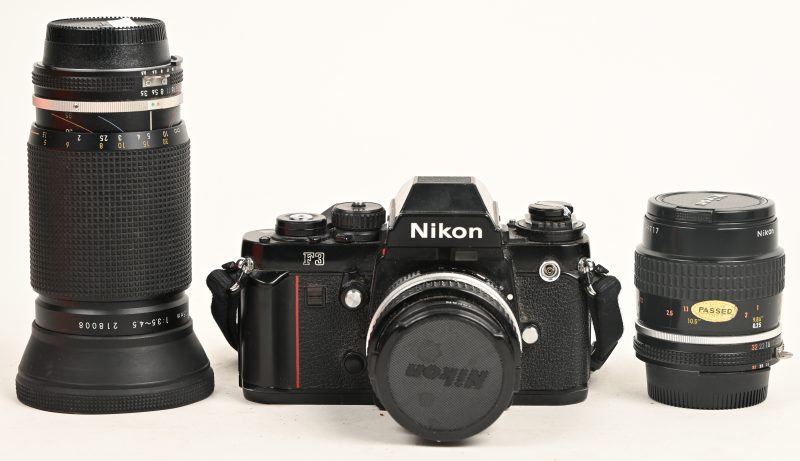 Een analoog fototoestel, Nikon F3 met 3 lenzen: 20mm 1:3.5 + 55mm 1:2.8 + 35-135mm 1:3.5-4.5.