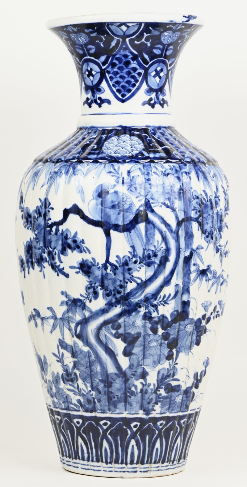 Een Japans porseleinen Arita vaas, blauw wit, met verticale glooien in het reliëf en vogels in flora decor.