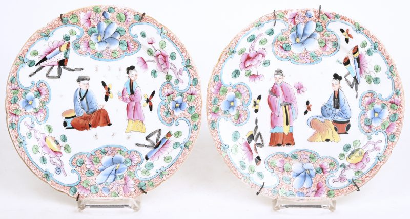Een paar Japans porseleinen borden met figuren en bloemen in het decor.