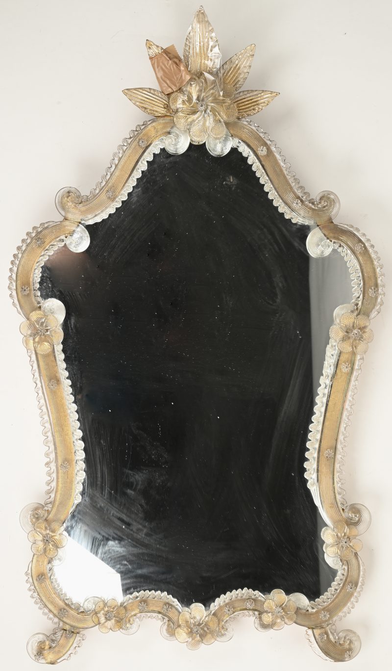 Een Murano spiegel met houten frame en glazen ornamenten. Enkele bladstukken aan bovenzijde afgebroken.