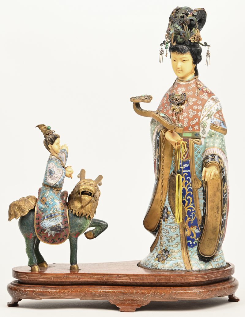 Een Japans cloisonné beeldje van vrouw en kind rijdend op een foo dog. Hoofden en handen uit ivorine. Op houten sokkel, enkele sporen van herstelling.