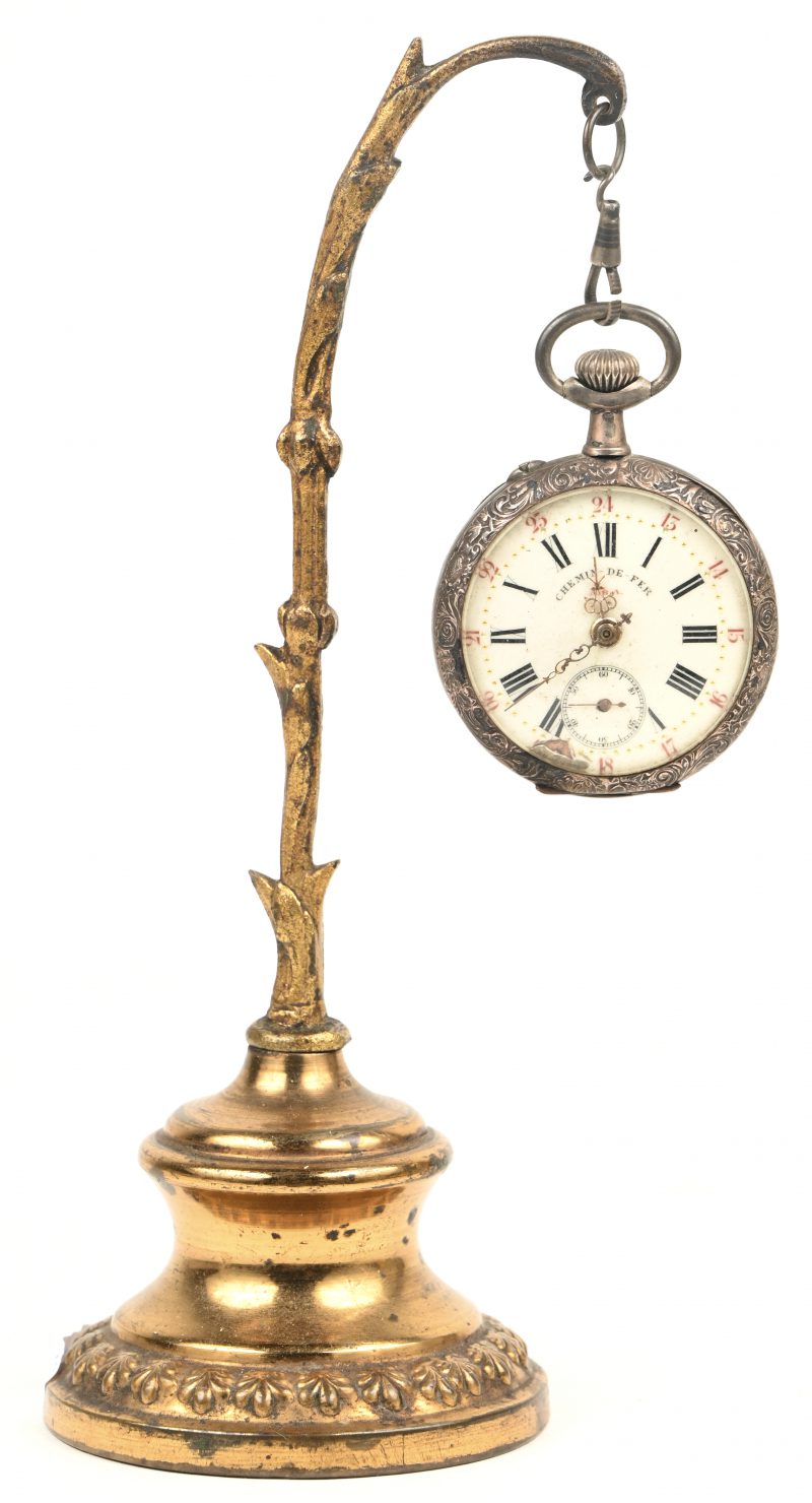 Een zilveren zakhorloge ‘Chemin de fer’ aan een staander. De horloge werkt niet en heefl schade aan de wijzerplaat.