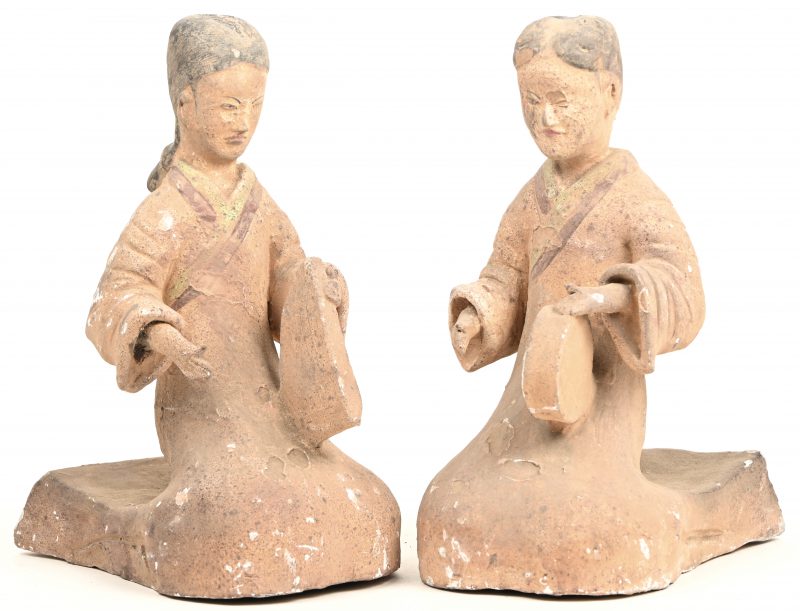 Een paar Chinese terracotta beeldjes van een duo muzikanten in geknielde zithouding.