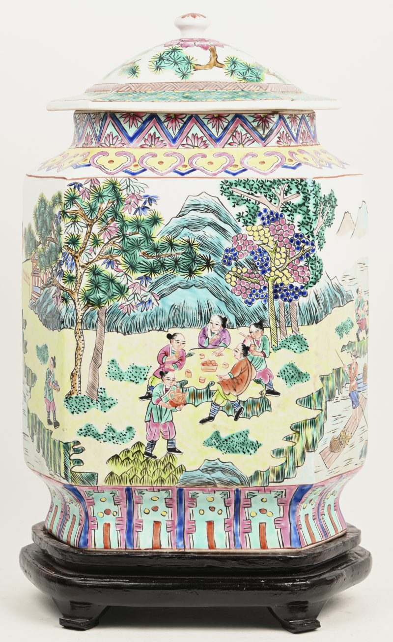 Een 6 hoekig Chinees porseleinen dekselvaas, meerkleurig met landschap en diverse kleuren in het decor. Onderaan gemerkt, op houten sokkel.